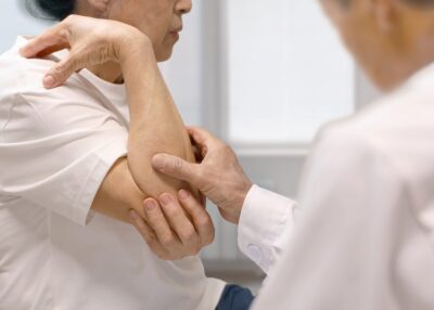 先生に肘を見てもらっている患者様